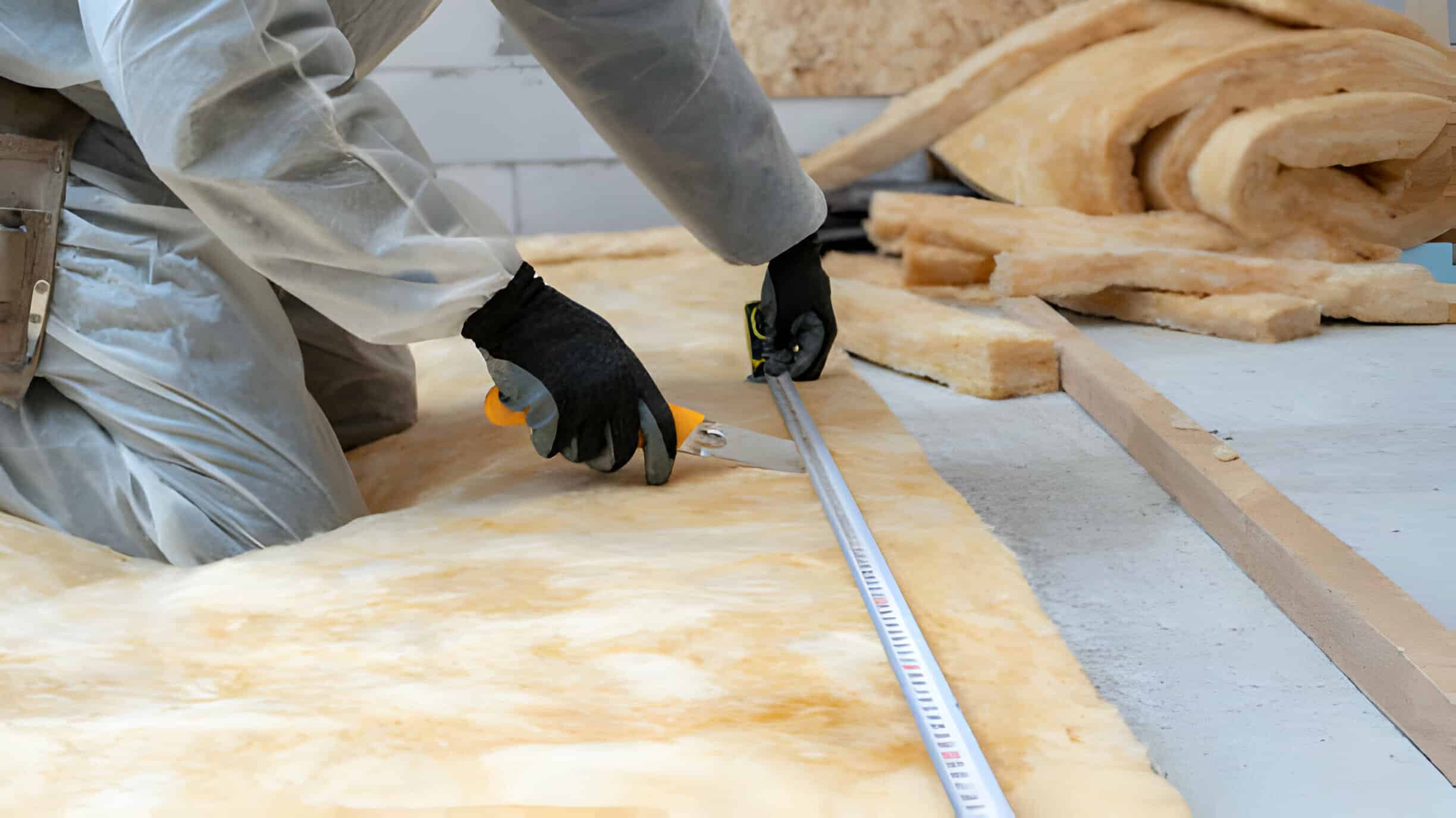 Installer injecting foam through a small access point in an exterior wall